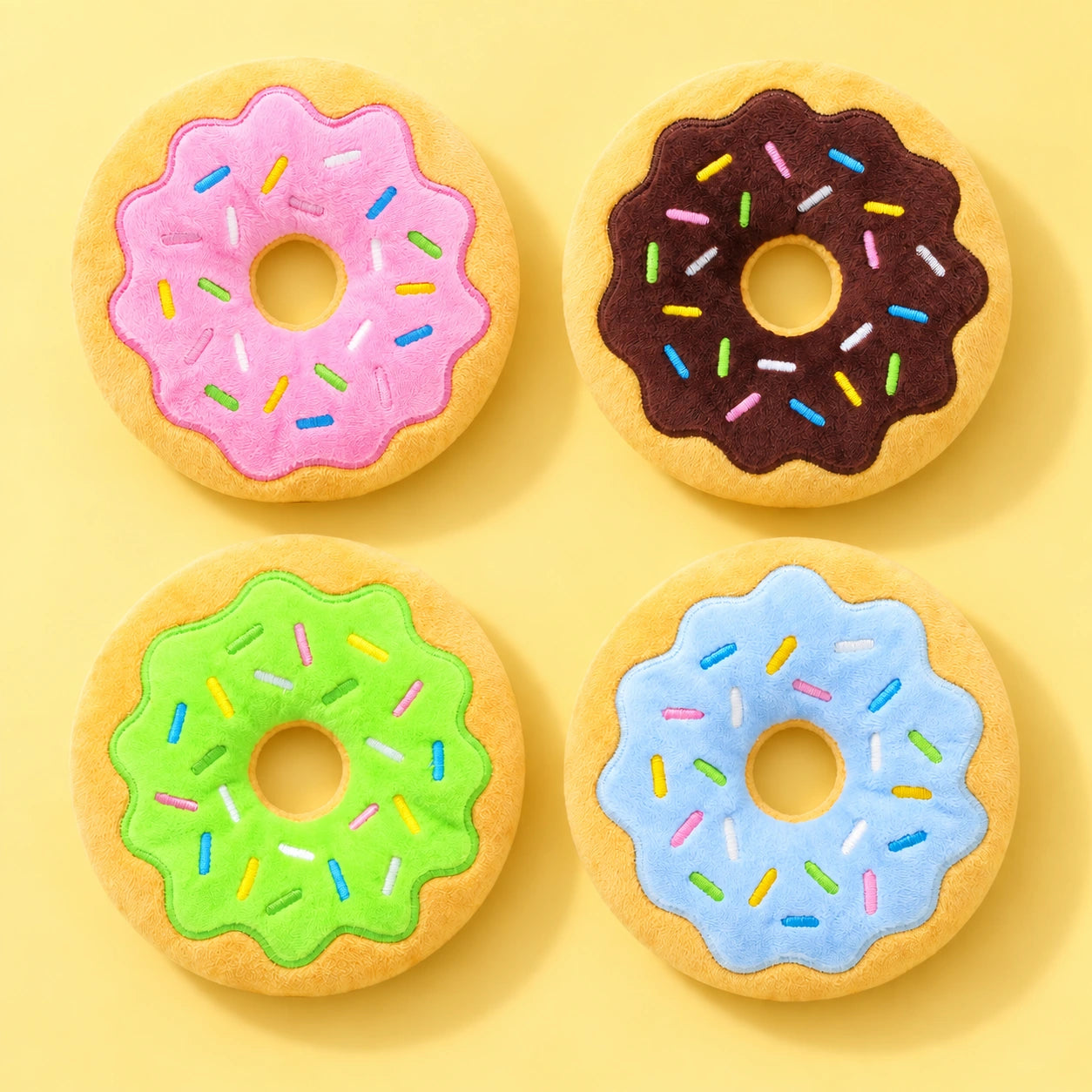Four plush donut colour options: Pink and Coffee above Green and Blue