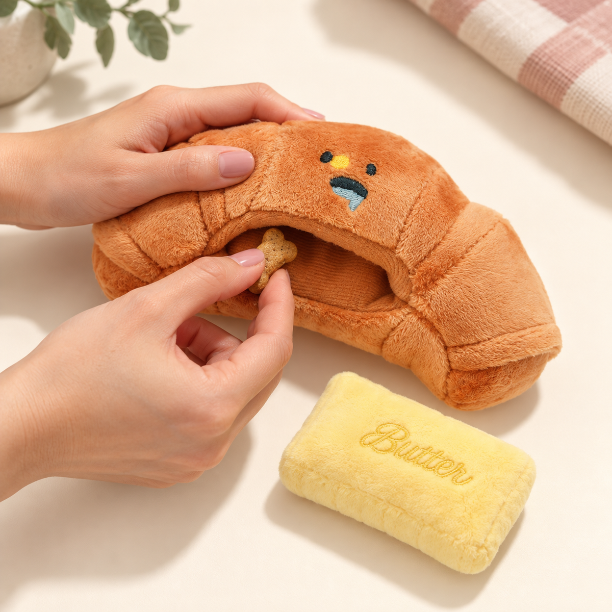 Hands placing a treat in the croissant toy pocket.